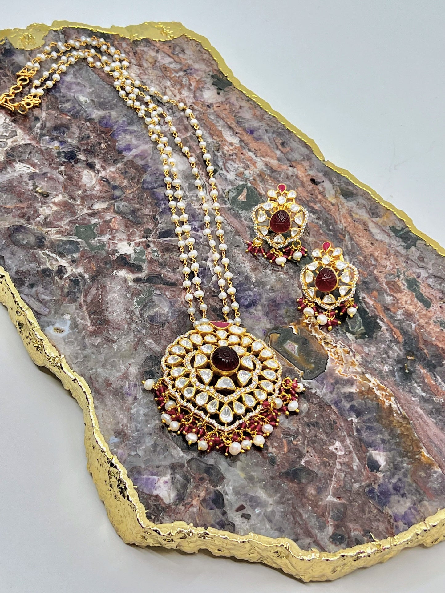 Carved ruby pendant necklace set in pearl chain