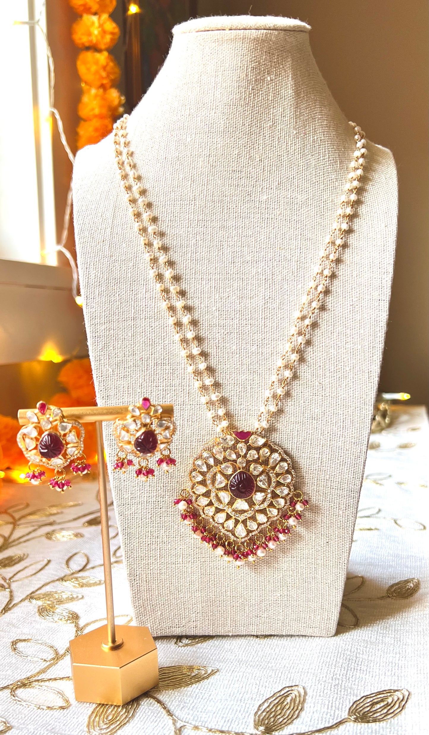 Carved ruby pendant necklace set in pearl chain